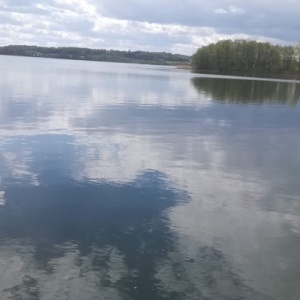 Jezioro Kłodno widok na wieś Zawory i zalesione wzgórza. 